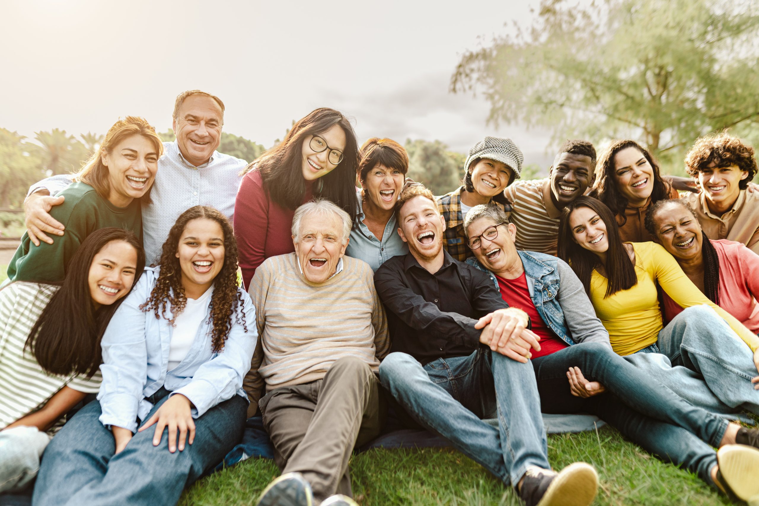 Happy multigenerational diverse group of people sitting together outside